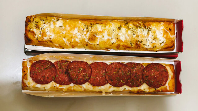 Savory baked cheesy casserole with melted mozzarella and pepperoni toppings in red rectangular baking dishes