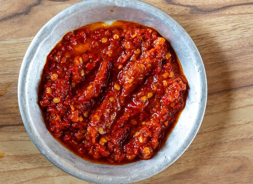 Traditional Indonesian spicy red chili paste (Sambal) in a rustic metal bowl