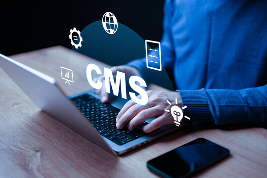 Working on a content management system at a desk with a laptop and smartphone
