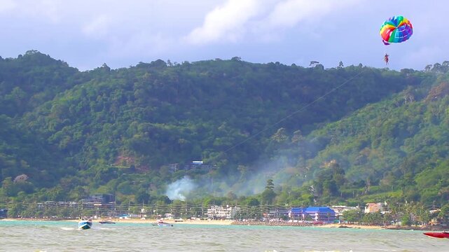 People tourism on parasailing parachute sport activity Patong Phuket Thailand.