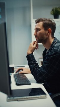 Vertical Screen : Young Caucasian male programmer writes code using multiple screens in home office. AI development, cybersecurity, network database system, software engineering, remote tech startup.