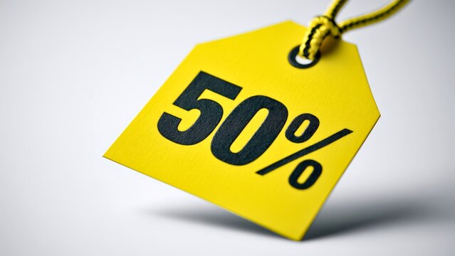 Yellow fifty percent discount paper price tag hanging on string with discount