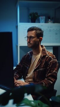 Vertical Screen : Young Caucasian male programmer write code on computer in office at night. AI technology, cybersecurity, software developer, freelance innovation, database system, digital network.