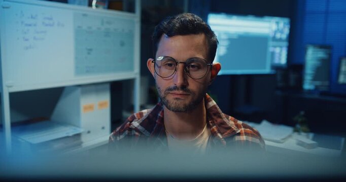 Young Caucasian male programmer write code on computer in home office at late night. AI technology, cybersecurity, software developer, freelance innovation, database system, digital network concept.