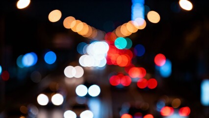 Fototapeta premium Cars move along a busy urban road, their headlights and taillights blending into a vibrant dance of colors against the dark night sky, creating an enchanting atmosphere.