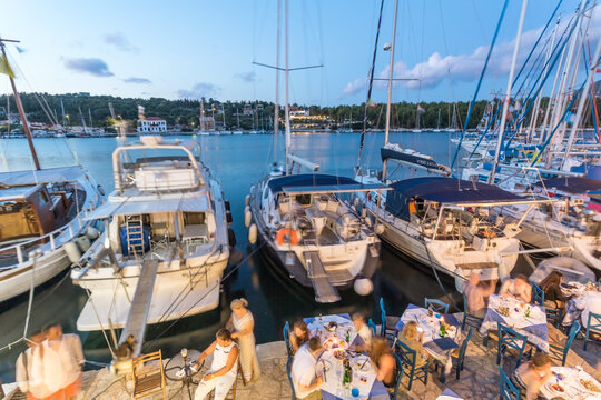 High angle view of people eating out in the harbour of Fiskardo on a summer evening, Kefalonia, Greek Islands, Greece