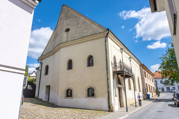 Fototapeta premium A Jewish synagogue stands in Boskovice, Czechia. The sunny day brings people walking near the building. The architecture shows unique design elements typical of the region.