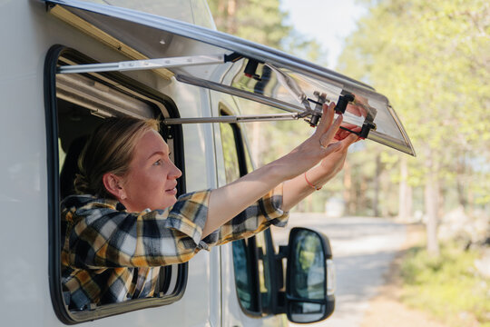 Woman opens a window on her camper van