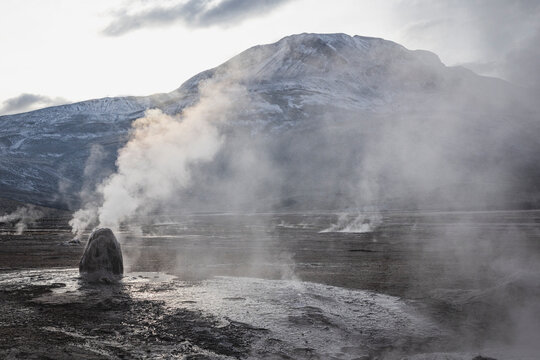 Steam vents from geysers in a mountain landscape