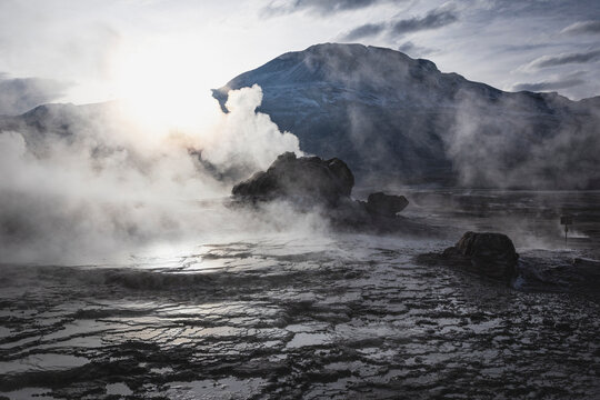 Sun rises over a dramatic steaming geyser field
