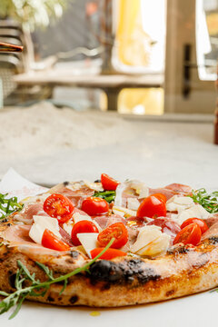 Pizza with prosciutto, arugula and tomatoes isolated