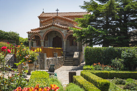 Quaint stone church in a sunny manicured garden