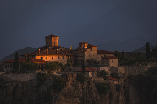 Ancient cliffside monastery glowing during golden hour