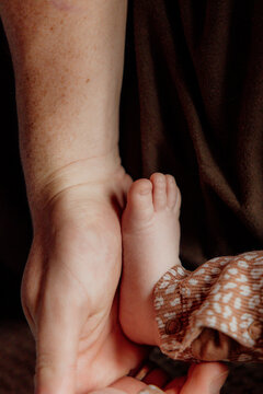 Close-up of newborn baby feet in parent's hands