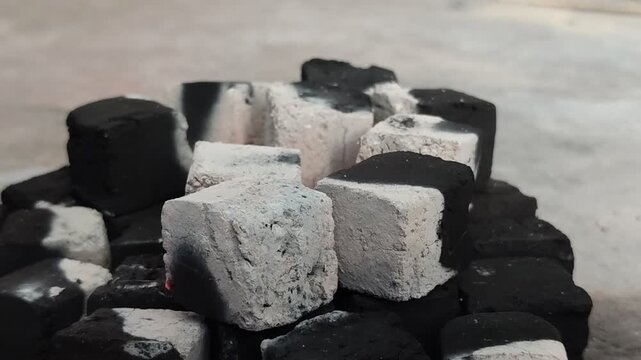 Burning charcoal briquettes with white ash. Made from renewable biomass waste and produces little ash