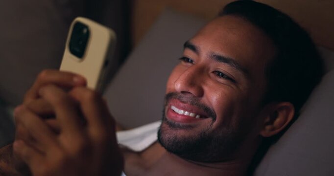 Night, relax or happy man with phone in bedroom for online browsing, network or adult website. Male person, smile and biting lip with mobile smartphone in bed for social media, internet or connection