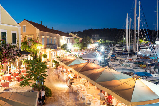 People eating out in the harbour of Fiskardo on a summer evening, Kefalonia, Greek Islands, Greece