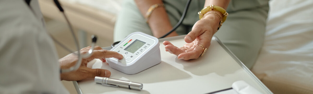 Senior patient receiving blood pressure check during doctor visit in clinic, supporting preventive healthcare and routine medical care. Ideal for wellness campaigns and senior care marketing, header