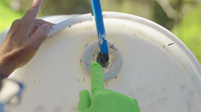 Person With Gloves Applying Silicone To The Perimeter Of Waterproof Exterior Air Vent. Close-up Shot