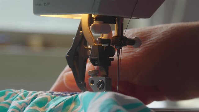 Close-up Of A Blue Color With Design Fabric Under A Sewing Machine.