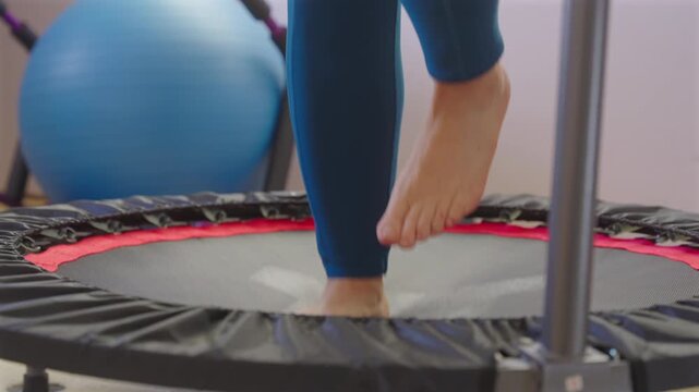 Cropped View Of A Woman Using Mini Rebounder Cardio Fitness Trampoline At Home. Close-up Shot
