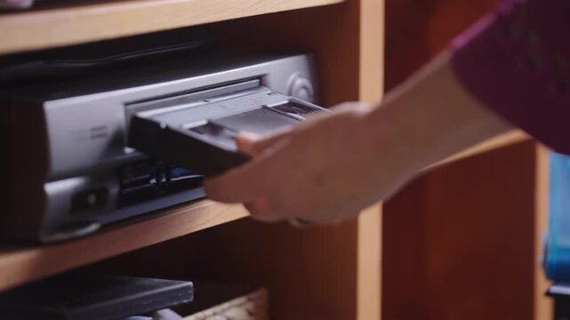 Close-up Of A Hand Inserting VHS Tape Into A Video Player.