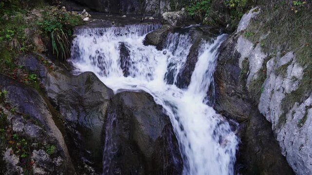Small Waterfall Flowing Over Rocks and Plants Static Shot