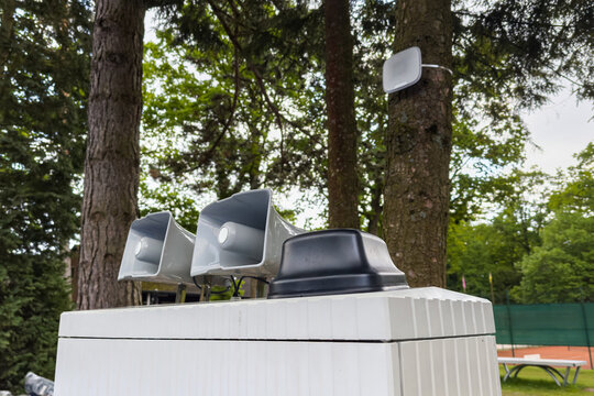 Speakers and equipment near trees at a park during daytime
