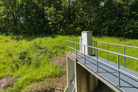 Water control structure near green landscape in sunny weather