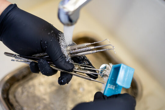 Dental Instruments Being Cleaned Under Running Water