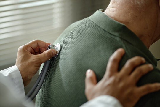Senior patient receiving chest examination from doctor in clinic, showing preventive healthcare and medical consultation. Ideal for insurance, senior care, wellness marketing