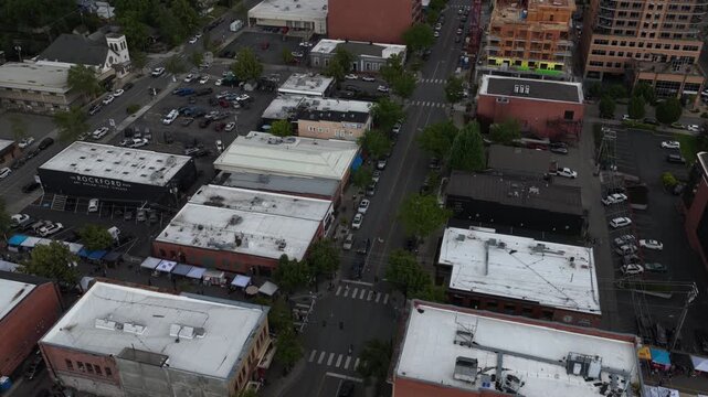 Aerial of commercial district and downtown streets in Coeur dAlene Idaho showing multiple buildings and parked vehicles in spring