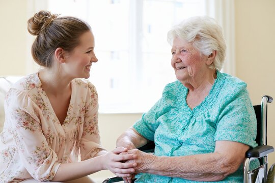 The Compassionate Moment Between Caregiver and Elderly Woman Sharing Hands