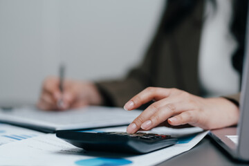 Fototapeta premium Business people hands working with a calculator and financial documents at an office desk, corporate accountant auditing data, planning budget or investment