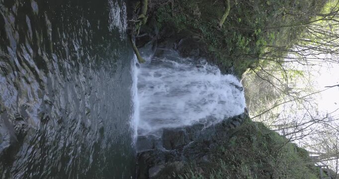 vertical shot of Gleno Waterfall with a constant stream of water falling