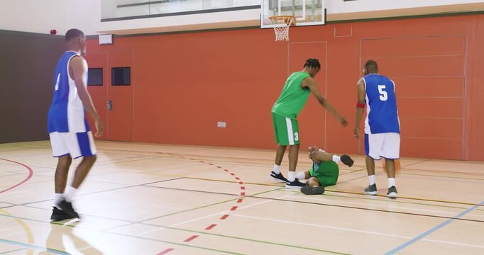 Man in green jersey dribbling at free-throw line while blue defender stealing ball forcing turnover