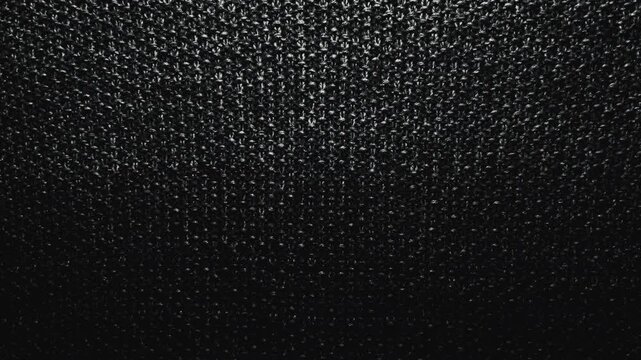cinematic macro panning shot reveals intricate black knitted wool fabric texture under dramatic moody lighting