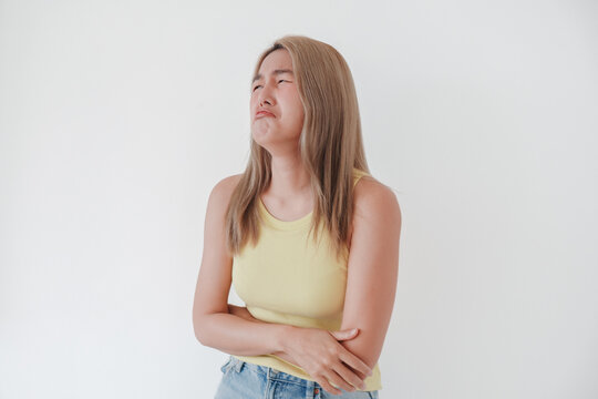 Young Thai woman showing a strong disgusted expression, feeling repulsed or unwell.