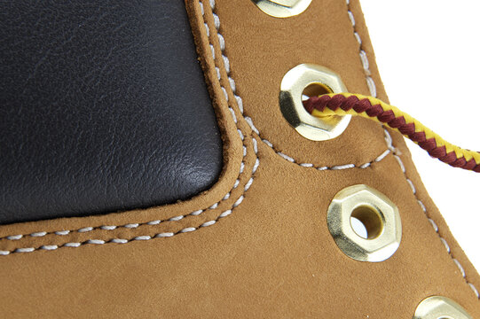 Close-up of tan nubuck leather boot with black panel and brass eyelets