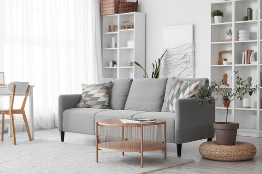 Interior of living room with cozy grey sofa and wooden coffee table