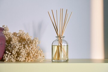 Fototapeta premium Glass reed diffuser with soft floral decor and sunlight