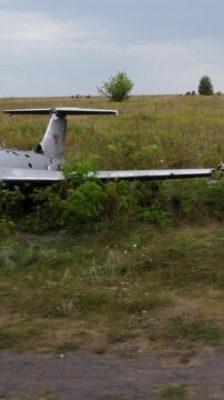 Trucking shot of abandoned trainer aircrafts Aero L-29 on old overgrown airfield