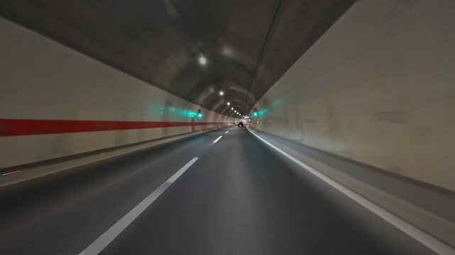 POV fast driving on modern highway and inside tunnel with bright lights illuminating road at night. Transportation and travel concept, 4k
