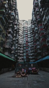 Empty street market and old furniture in yard of Monster building. Old apartment complex of five connected multistory houses in Asian megapolis vertical shot