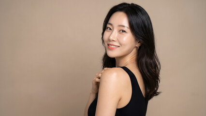 Naklejka premium Beautiful Asian woman smiling at camera with clean glowing skin and copy space on background