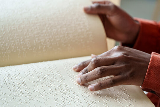 Hand of woman reading text from braille