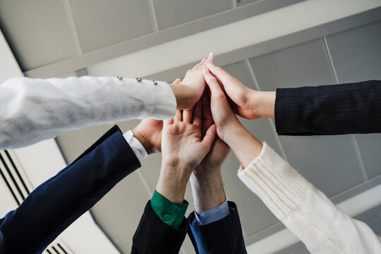 Business colleagues stacking hands in office