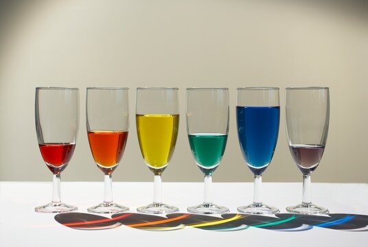 Row of glasses with colored liquid forming a conceptual bar chart