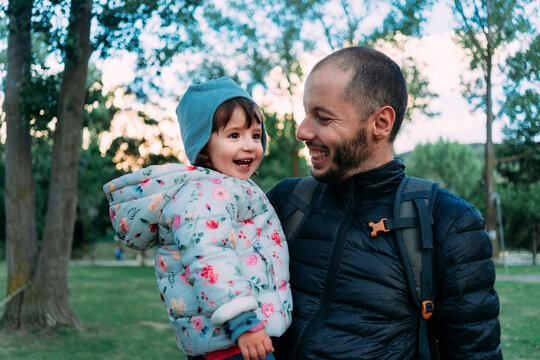 Father and little daughter having fun together in autumnal park