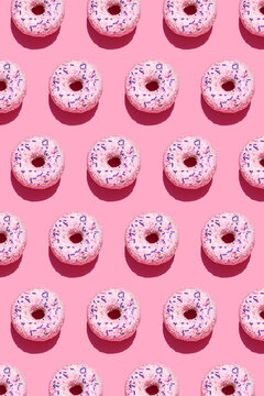 Pattern of sweet doughnuts against pink background